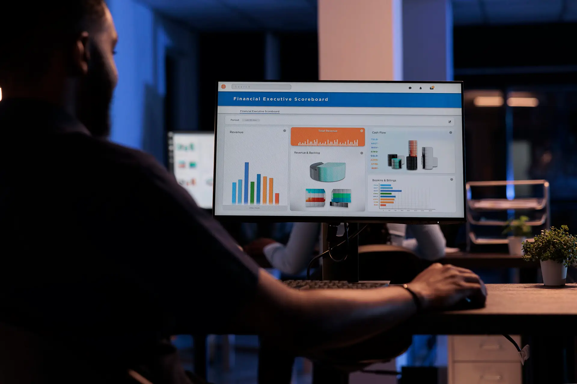 Young businessman looking at computer monitor with charts